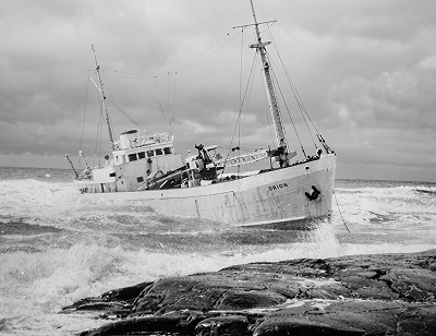 The coastal freighter Brion aground on the rocks, listing, photographed in 1976.