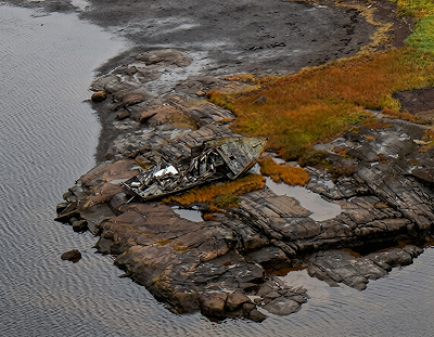 The broken hull of a small fishing boat lying on the shore at Pointe à David.
