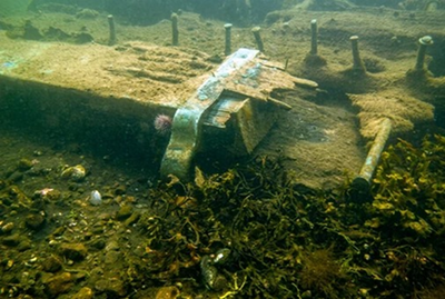 A copper gudgeon still fixed in place on the sternpost, seen underwater.