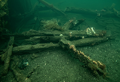 A run of wooden frames from the wreck lying on the seabed, still in sequence.